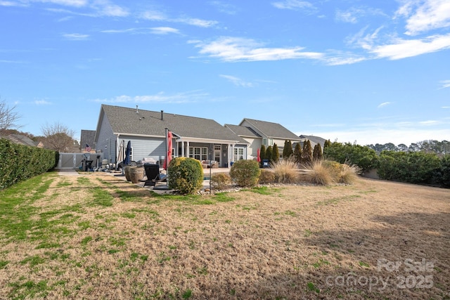 back of property with a yard, a patio area, and fence