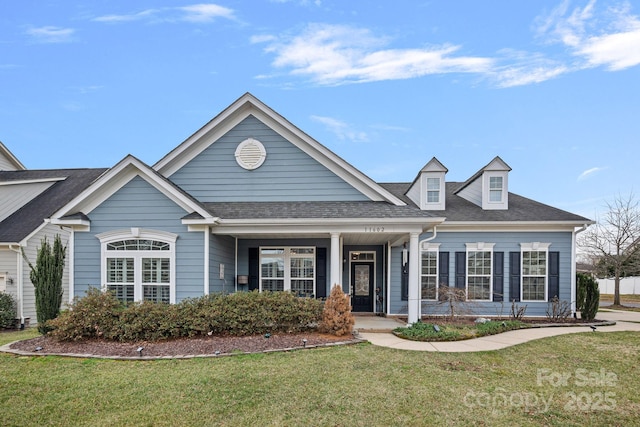 view of front of property featuring a front lawn and roof with shingles