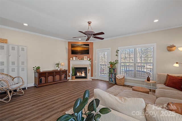 living room with dark wood-type flooring, crown molding, and ceiling fan