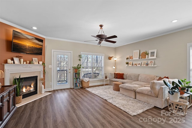 living room featuring hardwood / wood-style flooring, ornamental molding, and a high end fireplace