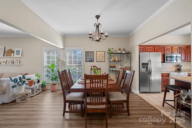 dining area featuring a chandelier, crown molding, and light hardwood / wood-style flooring