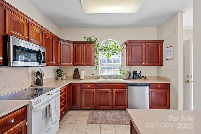 kitchen with light tile patterned flooring, appliances with stainless steel finishes, and sink