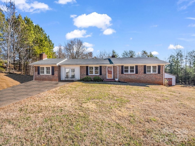 single story home with french doors, a chimney, a front lawn, and brick siding