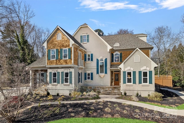 view of front of property with fence and roof with shingles