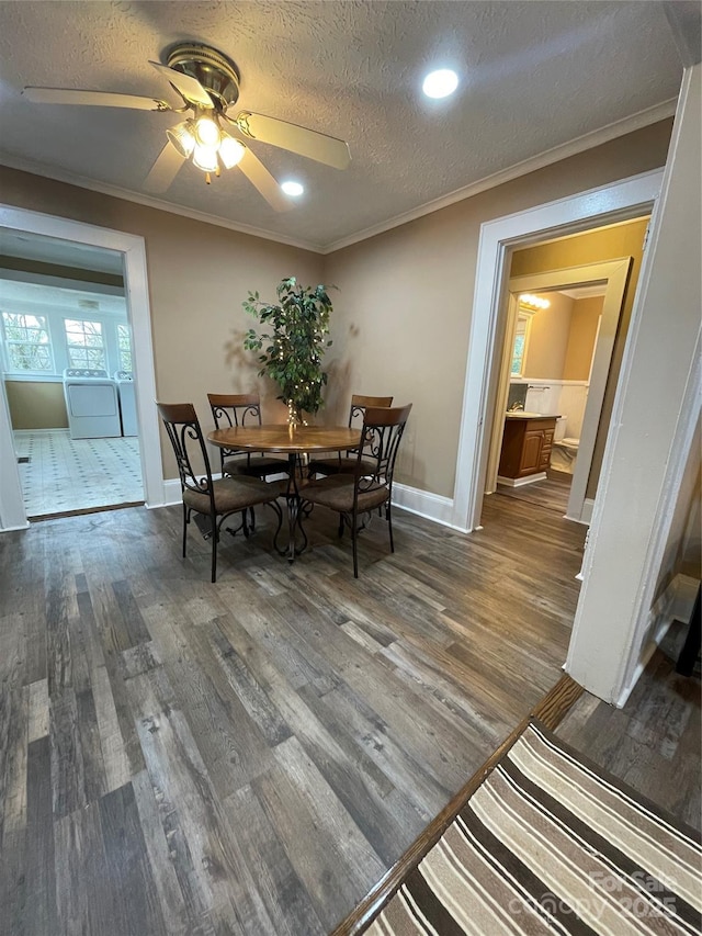 dining area featuring crown molding, washer and clothes dryer, and dark wood-style flooring