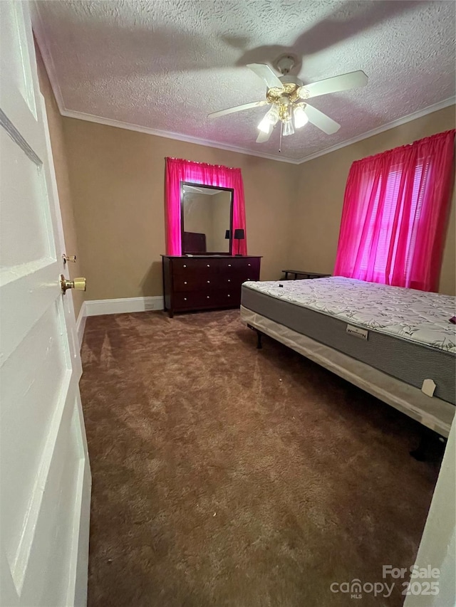 carpeted bedroom with a textured ceiling, ornamental molding, a ceiling fan, and baseboards