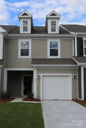 view of property featuring a garage, concrete driveway, and a front yard