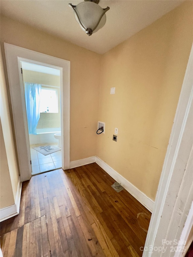 clothes washing area featuring hookup for an electric dryer, laundry area, washer hookup, wood finished floors, and baseboards