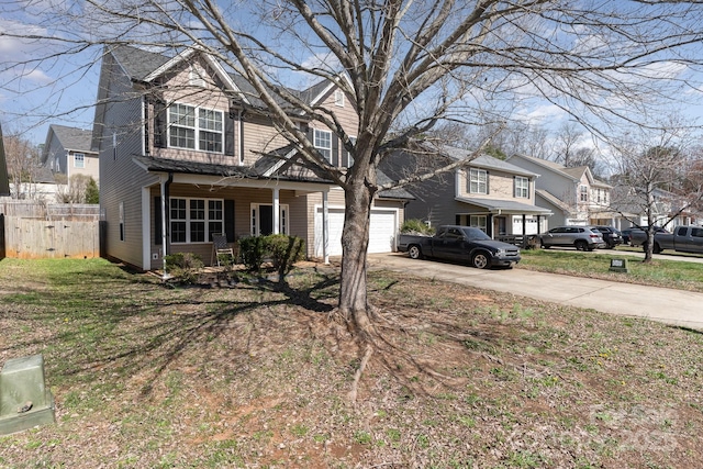 traditional home with a residential view, concrete driveway, and fence