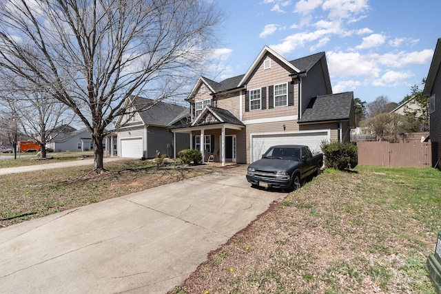 traditional home with concrete driveway, roof with shingles, a garage, and fence