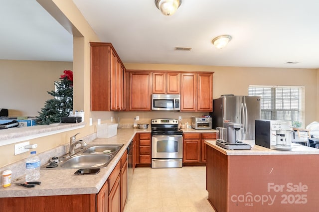 kitchen with visible vents, stainless steel appliances, light countertops, and a sink