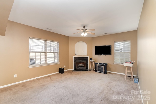 living room featuring a ceiling fan, carpet, visible vents, and a healthy amount of sunlight