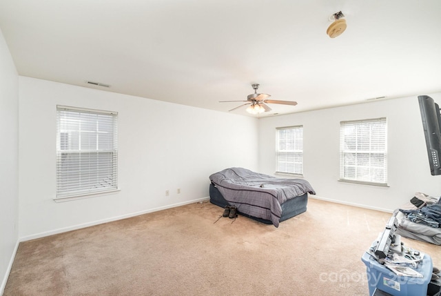 carpeted bedroom with a ceiling fan, baseboards, and visible vents