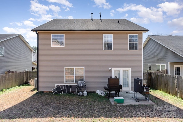 back of property with a patio area, a fenced backyard, and roof with shingles