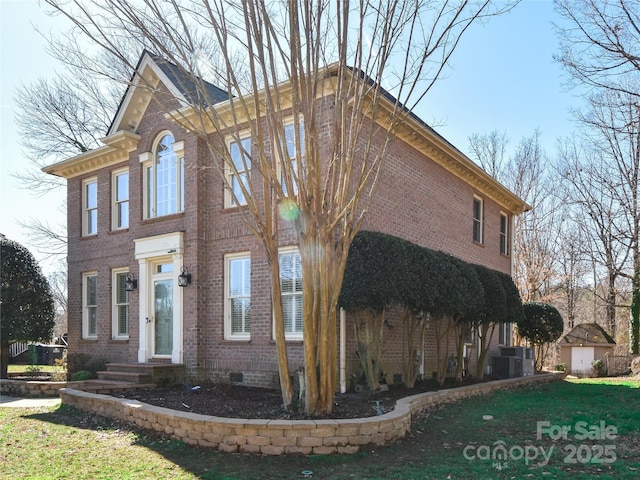 view of front of home with a front yard and central AC unit