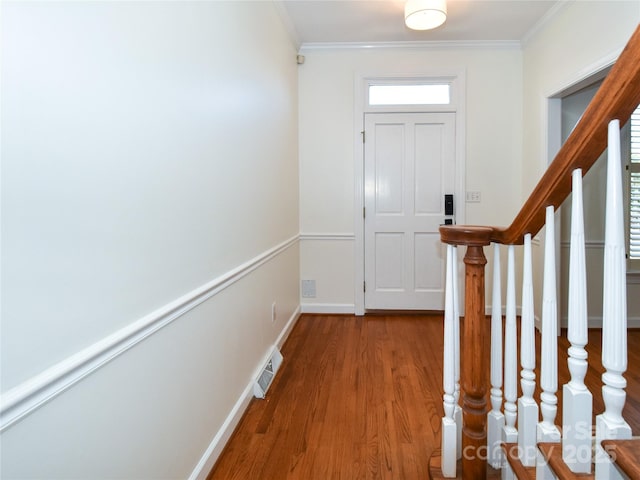 entryway with hardwood / wood-style floors and ornamental molding