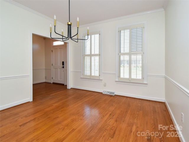 interior space with wood-type flooring, crown molding, and a notable chandelier