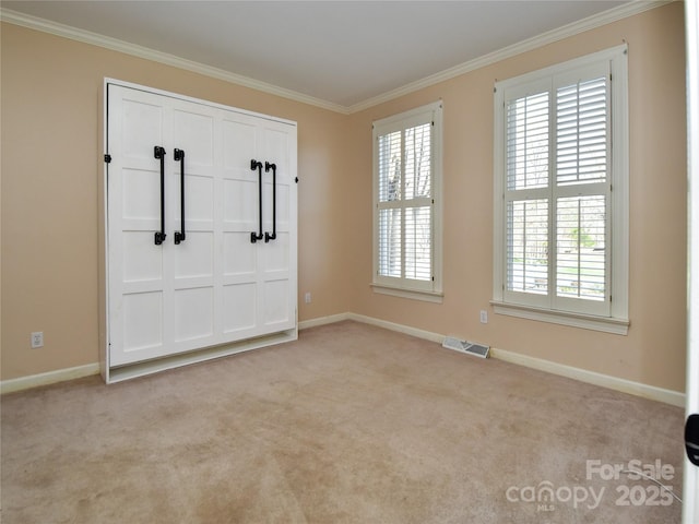 carpeted entryway with a wealth of natural light and crown molding