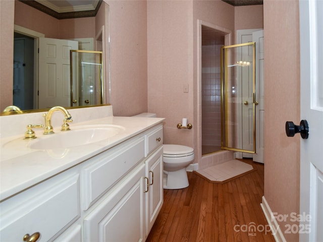 bathroom with vanity, a shower with door, toilet, and hardwood / wood-style floors