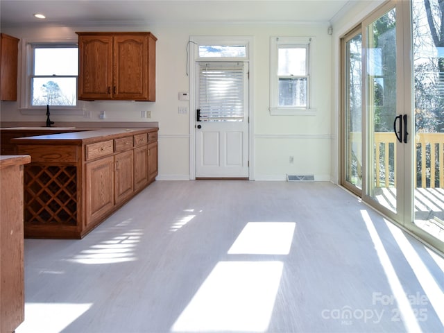 kitchen featuring light hardwood / wood-style floors and crown molding