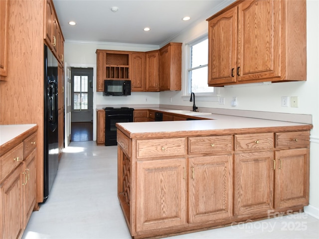 kitchen with sink, kitchen peninsula, crown molding, and black appliances