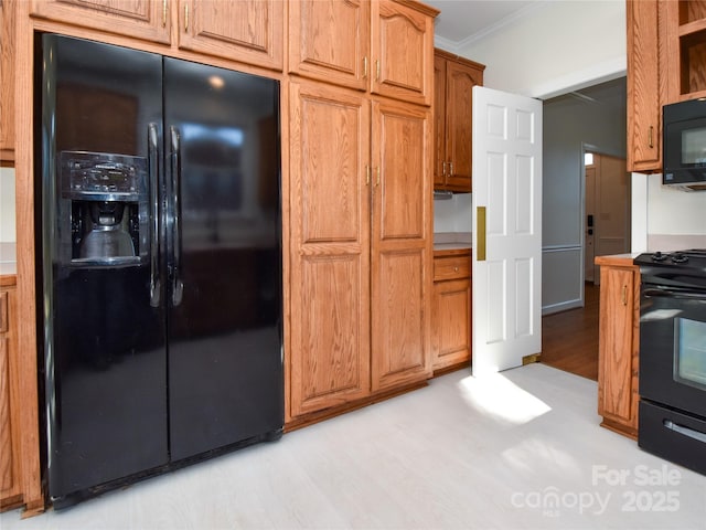 kitchen featuring ornamental molding, black appliances, and light hardwood / wood-style flooring