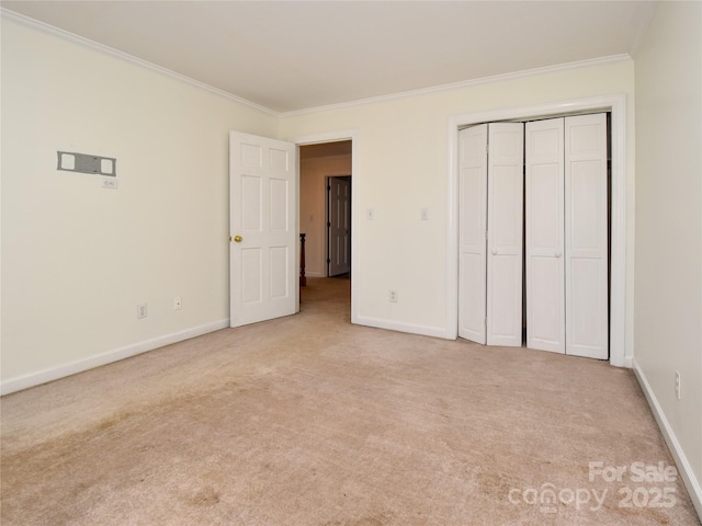 unfurnished bedroom with ornamental molding, light carpet, and a closet