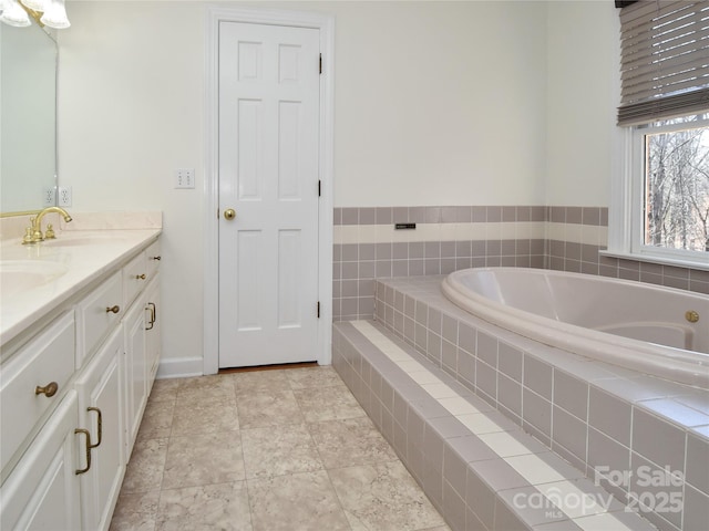 bathroom with vanity and tiled tub