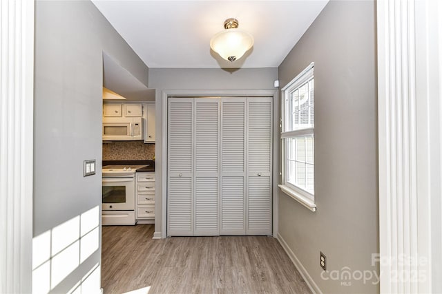 interior space with light wood finished floors and baseboards