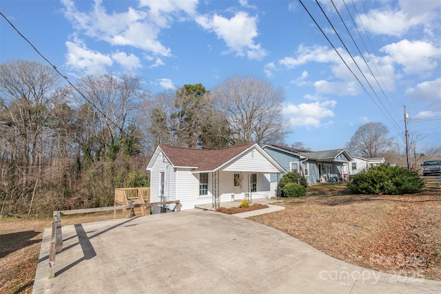 view of front of house featuring covered porch, driveway, and a shingled roof