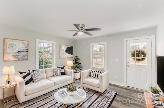 living room featuring wood finished floors, a ceiling fan, and baseboards