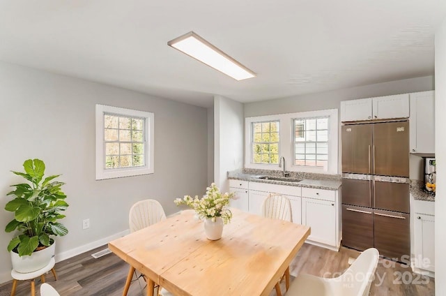 dining space with visible vents, a healthy amount of sunlight, and light wood-style flooring