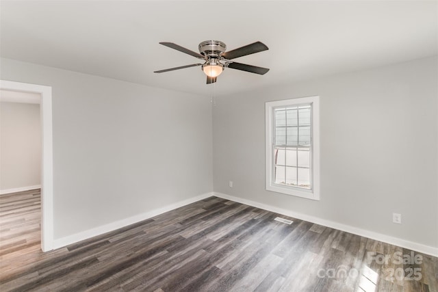 unfurnished room with ceiling fan, visible vents, baseboards, and dark wood-style flooring