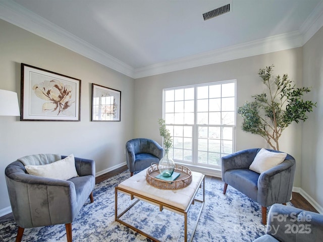 living area with plenty of natural light, crown molding, and hardwood / wood-style flooring