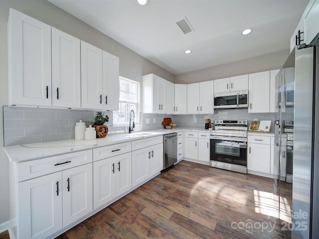 kitchen featuring white cabinets, stainless steel appliances, dark wood-type flooring, and sink