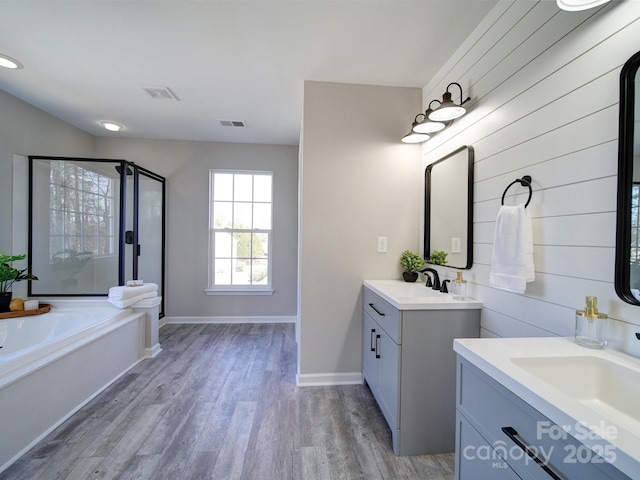 bathroom featuring separate shower and tub, vanity, and wood-type flooring