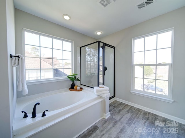 bathroom with hardwood / wood-style floors and shower with separate bathtub