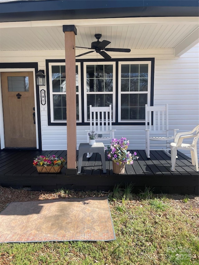 view of exterior entry featuring ceiling fan and a porch