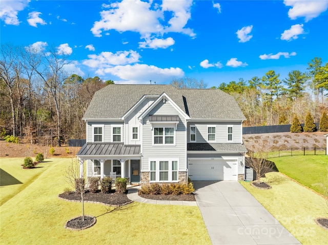 view of front facade with a garage, a porch, a front lawn, and a standing seam roof