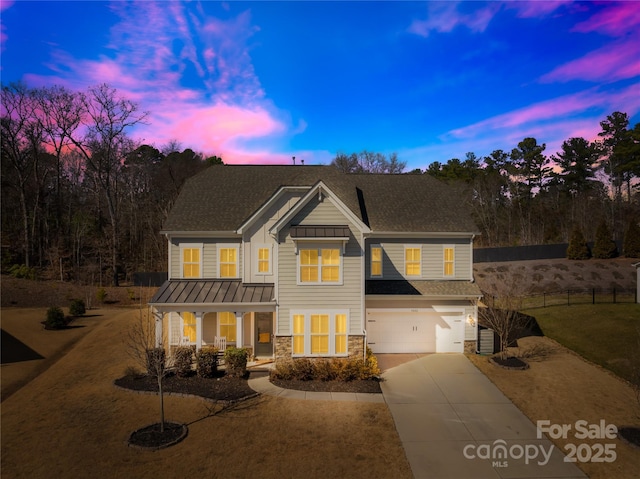 view of front of home featuring a garage, concrete driveway, stone siding, covered porch, and a standing seam roof