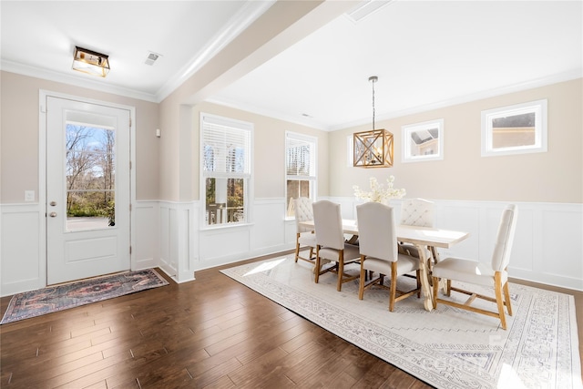 dining room featuring crown molding, dark wood finished floors, and a wealth of natural light