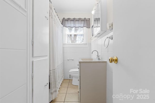 bathroom featuring tile walls, vanity, tile patterned flooring, and toilet