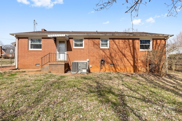 back of property featuring central air condition unit and a yard