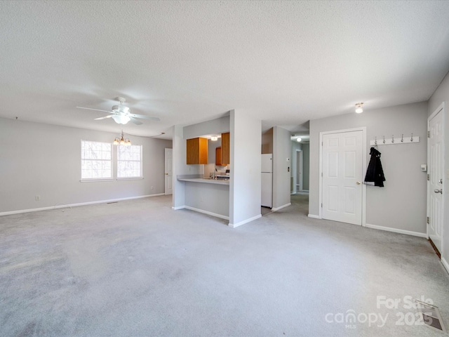 unfurnished living room featuring light carpet, ceiling fan, a textured ceiling, and baseboards