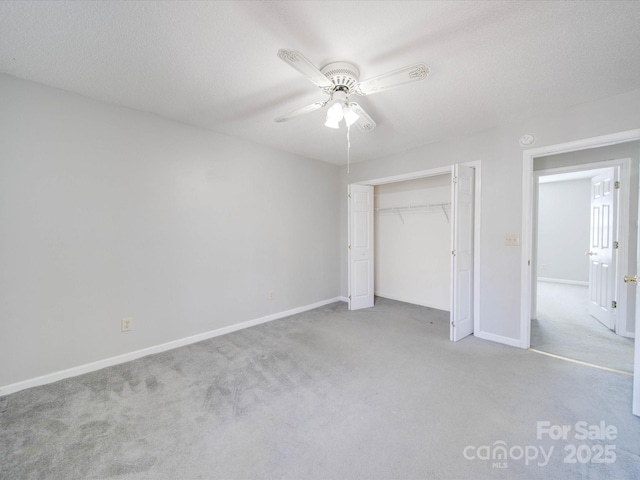 unfurnished bedroom featuring carpet floors, a textured ceiling, baseboards, and a closet