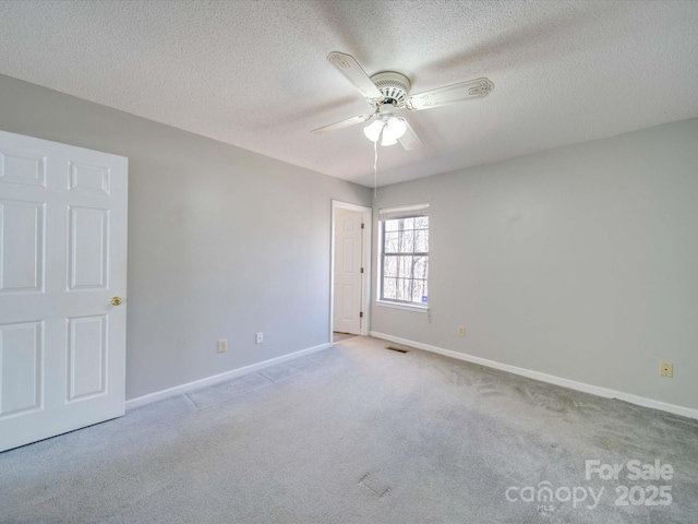 unfurnished room with ceiling fan, a textured ceiling, visible vents, baseboards, and carpet