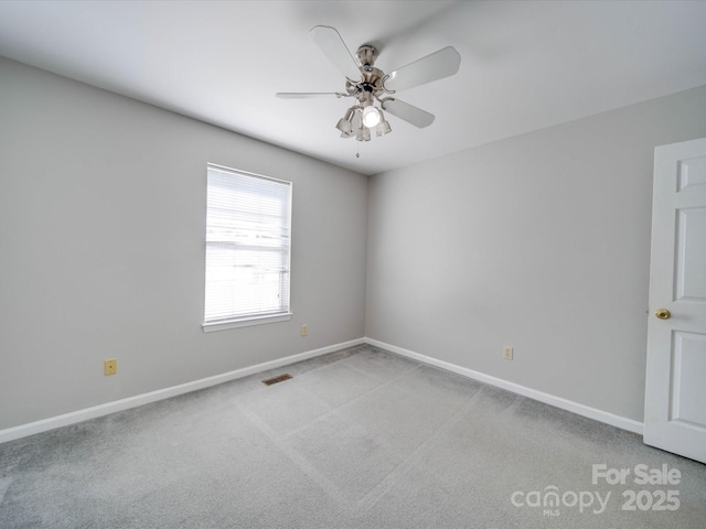 spare room featuring ceiling fan, light carpet, visible vents, and baseboards