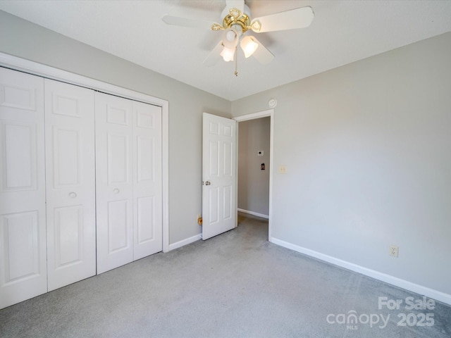 unfurnished bedroom with a ceiling fan, a closet, baseboards, and carpet flooring