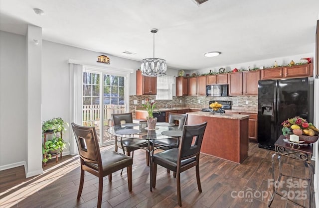 dining room with visible vents, baseboards, dark wood finished floors, and a chandelier