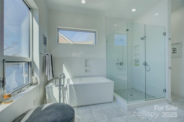 bathroom featuring recessed lighting, a freestanding bath, and a shower stall